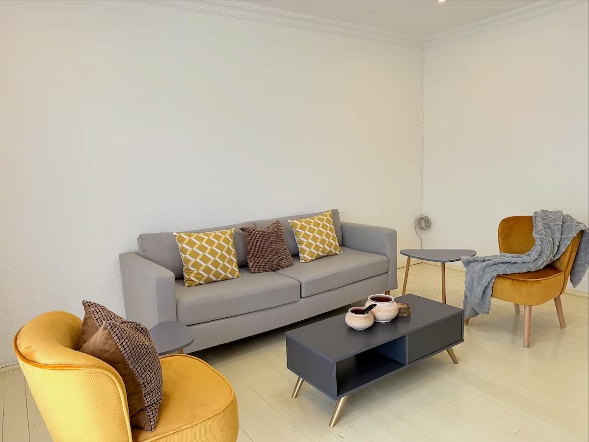 Lounge seating area with grey sofa and mustard velvet armchairs