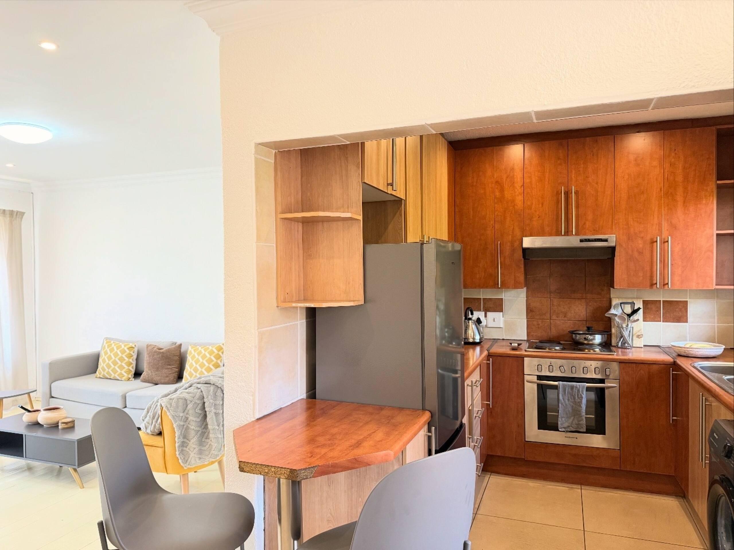 Open-plan kitchen with wood-toned cabinetry, off the lounge