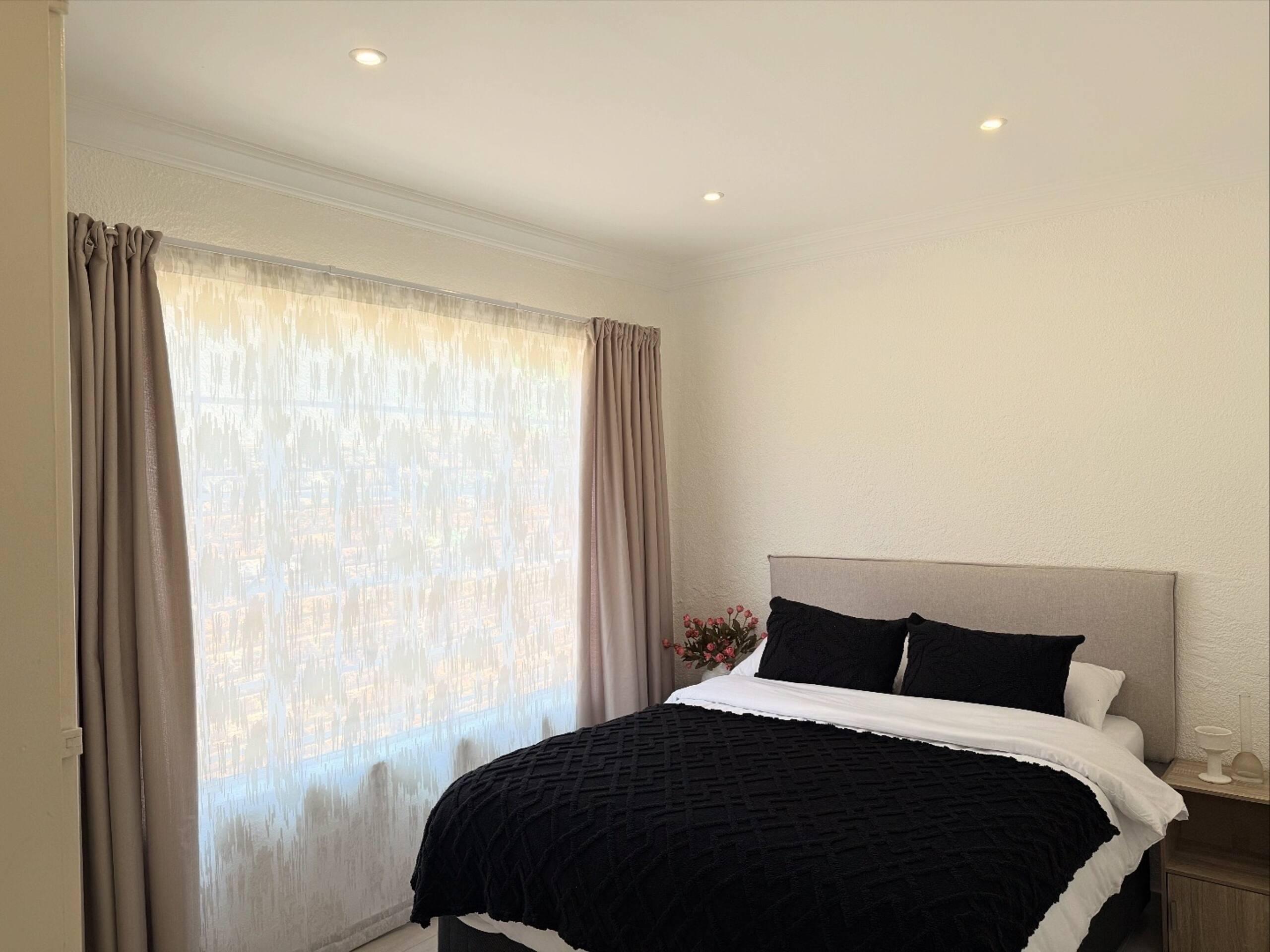 Bedroom with upholstered headboard and black-and-white linen