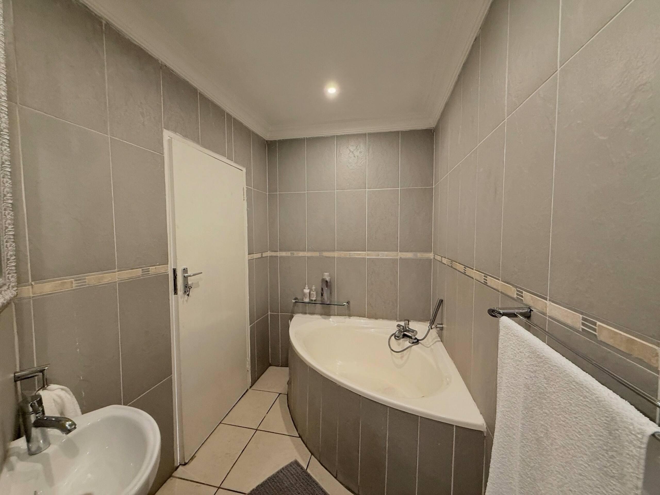 Bathroom with corner tub and tiled surround