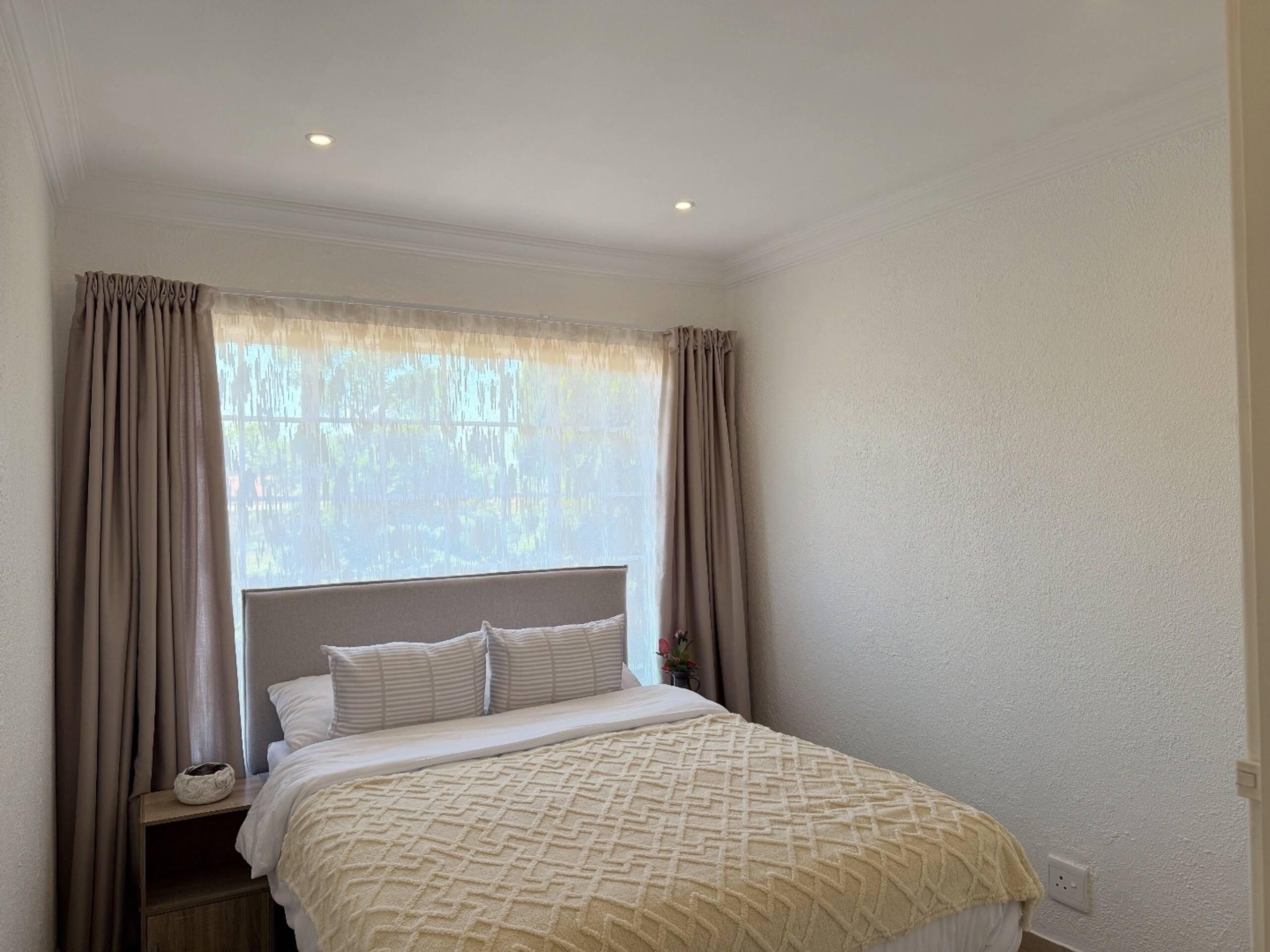 Bedroom with garden-facing window and neutral linen